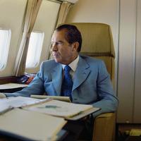 President Richard Nixon seated on board Air Force One en route to China.