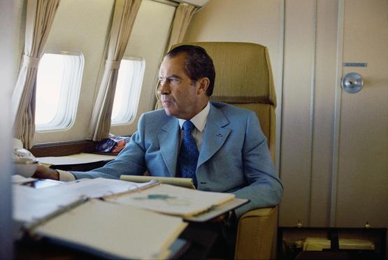 President Richard Nixon seated on board Air Force One en route to China.